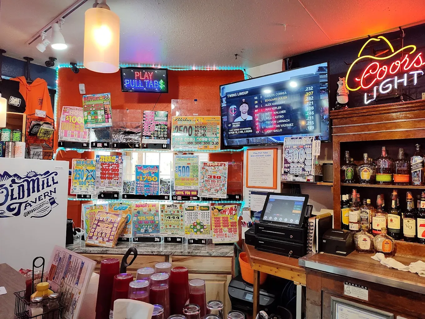 Bar seating with sports on the TVs and neon beer signs at Old Mill Tavern in Peshastin, WA