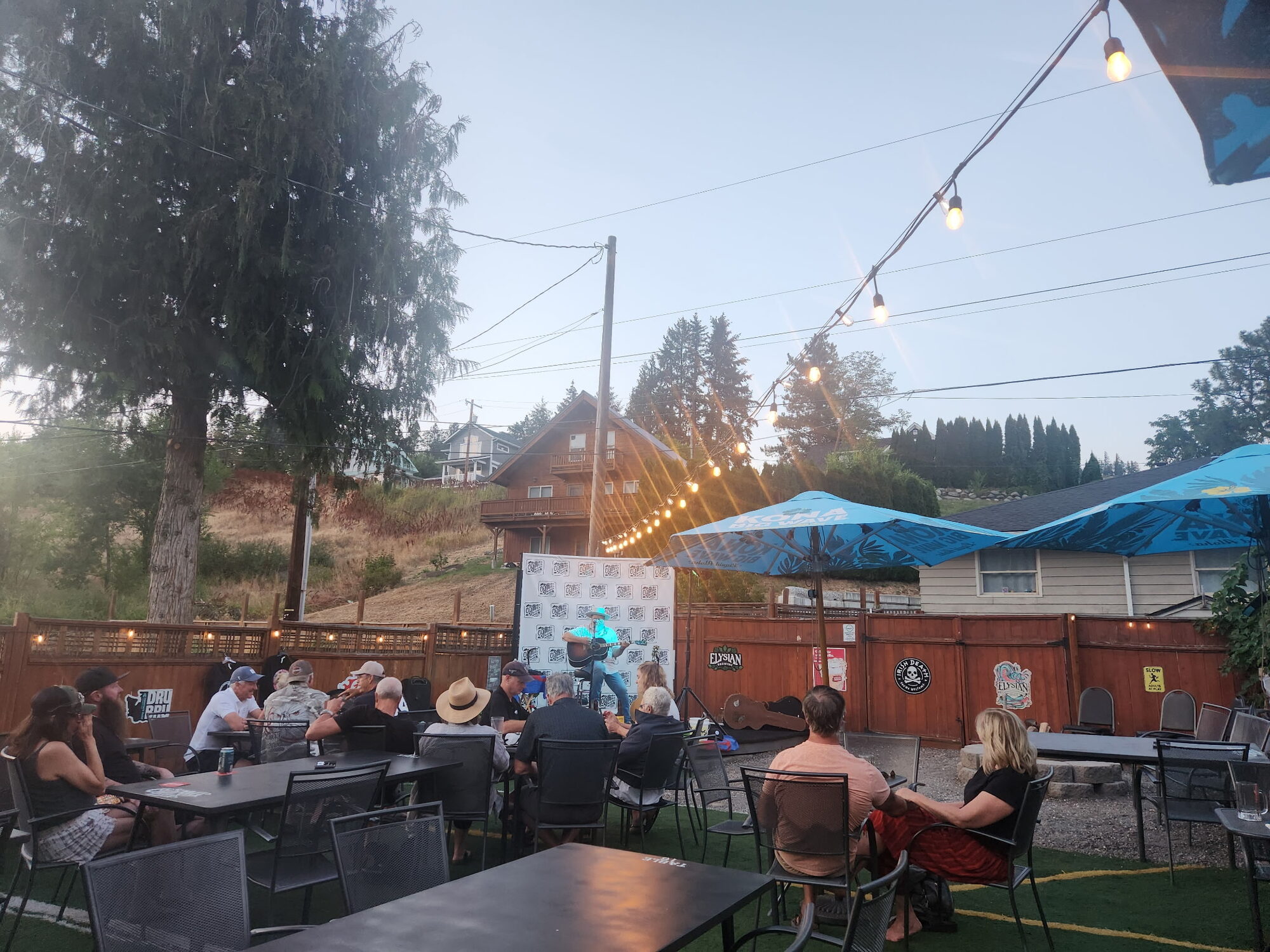 Backyard patio full of guests under string lights at dusk at Old Mill Tavern in Peshastin, WA