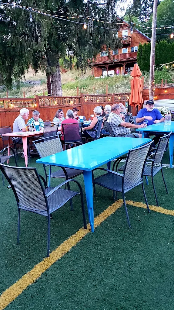 Daytime patio with turquoise tables and turf at Old Mill Tavern in Peshastin, WA