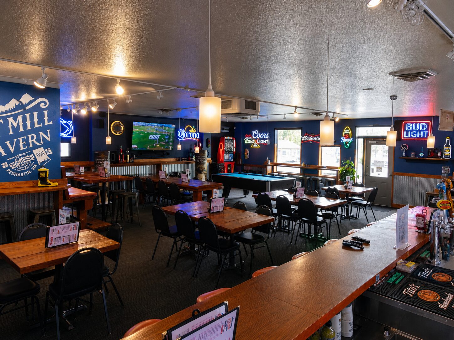 Neon-lit dining room with booths and beer signs at Old Mill Tavern in Peshastin, WA