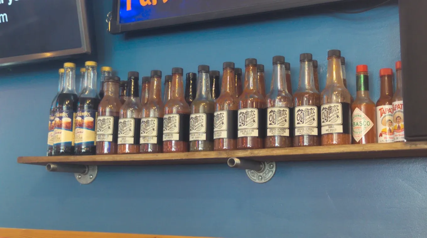 Shelf of hot sauce bottles behind the bar at Old Mill Tavern in Peshastin, WA